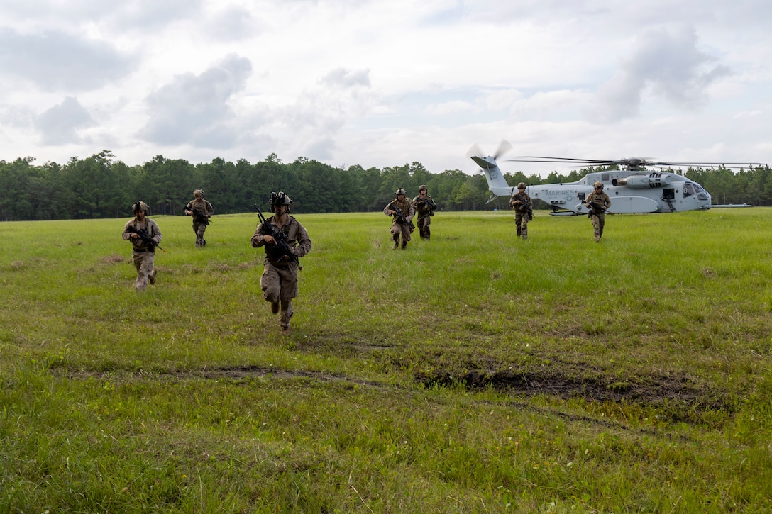 U.S. Marines and Sailors with 2nd Air Naval Gunfire Liaison Company, II Marine Expeditionary Force Information Group, and NATO allies, return to their objective during a casualty evacuation drill as part of exercise Burmese Chase 25 at Marine Corps Base Camp Lejeune, North Carolina, Aug. 7, 2025. Burmese Chase is an annual U.S. led, multi-lateral training exercise comprised of integrating ground and air fires, infantry tactics and naval gunfire alongside NATO allies to enhance combat readiness and interoperability. (U.S. Marine Corps photo by Cpl. Marc Imprevert)