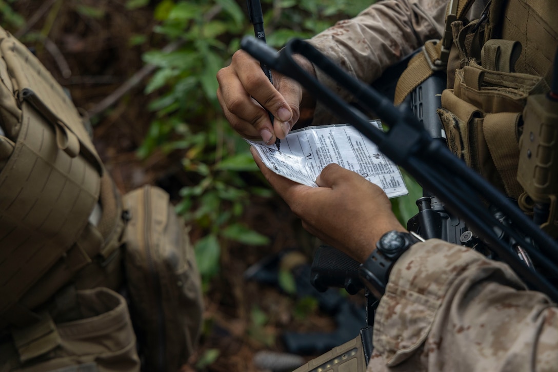 A U.S. Marine with 2nd Air Naval Gunfire Liaison Company, II Marine Expeditionary Force Information Group, fills out a casualty care card during a casualty evacuation drill as part of exercise Burmese Chase 25 at Marine Corps Base Camp Lejeune, North Carolina, Aug. 7, 2025. Burmese Chase is an annual U.S. led, multi-lateral training exercise comprised of integrating ground and air fires, infantry tactics and naval gunfire alongside NATO allies to enhance combat readiness and interoperability. (U.S. Marine Corps photo by Cpl. Marc Imprevert)