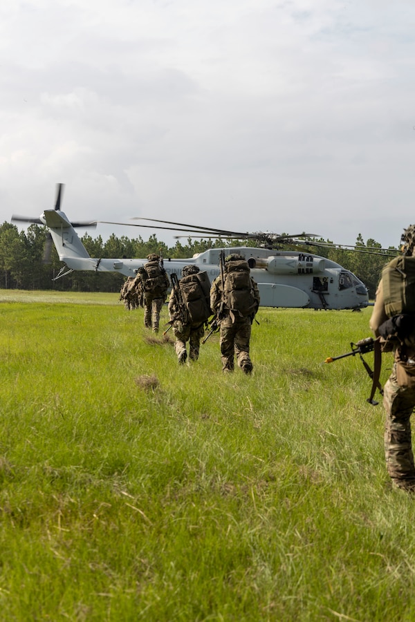 U.S. Marines and Sailors with 2nd Air Naval Gunfire Liaison Company, II Marine Expeditionary Force Information Group, and NATO allies, prepare to board a CH-53E Super Stallion with Marine Heavy Helicopter Squadron 461, Marine Aircraft Group 29, 2nd Marine Aircraft Wing, during a casualty evacuation drill as part of exercise Burmese Chase 25 at Marine Corps Base Camp Lejeune, North Carolina, Aug. 7, 2025. Burmese Chase is an annual U.S. led, multi-lateral training exercise comprised of integrating ground and air fires, infantry tactics and naval gunfire alongside NATO allies to enhance combat readiness and interoperability. (U.S. Marine Corps photo by Cpl. Marc Imprevert)