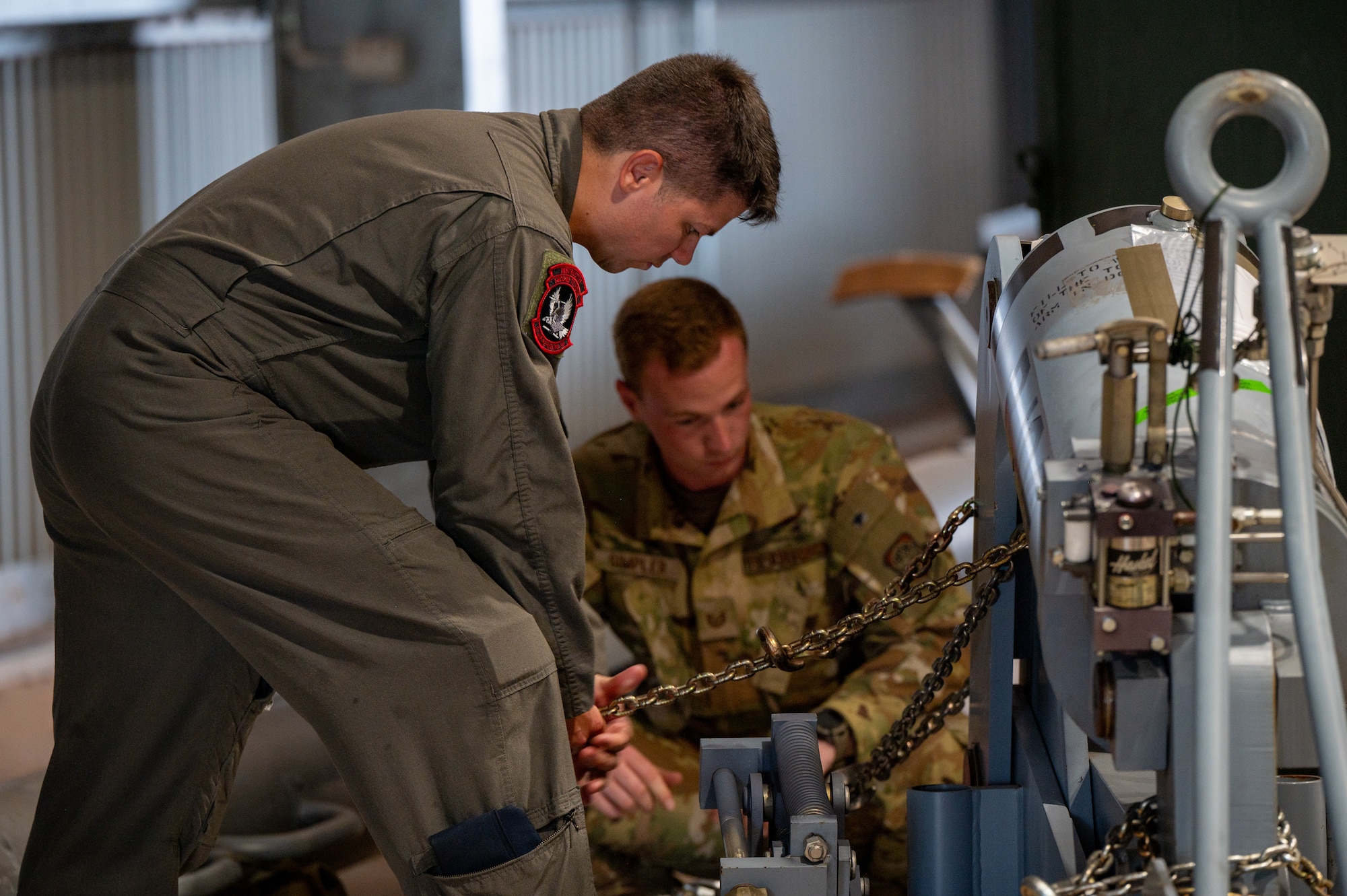 U.S. Air Force Master Sgt. Andrew Abney, left, 2nd Air Refueling Squadron boom operator and Talisman Sabre 2025 senior enlisted leader, secures cargo chains to a pallet during KC-46 operations in support of TS25 in Northern Territory, Australia, July 25, 2025. Talisman Sabre is the largest bilateral military exercise between Australia and the United States, that advances a safe and secure Indo-Pacific by strengthening relationships and interoperability among key Allies and partners, while enhancing collective capabilities to respond to a wide array of potential security concerns. (U.S. Air Force photo by Senior Airman Clare Werner)