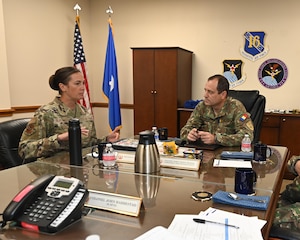 Leadership sits at table to discuss cyber partnership.
