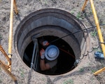 U.S. Air Force Tech. Sgt. Benjamin Dutting, a cable and antenna technician with the 212th Engineering Installation Squadron (EIS), feeds fiber optic cable through a communications conduit during an infrastructure upgrade on Otis Air National Guard Base, Massachusetts, August 8, 2025. Members of the 212th EIS performed a critical communications infrastructure upgrade while simultaneously performing hands-on training and qualification.