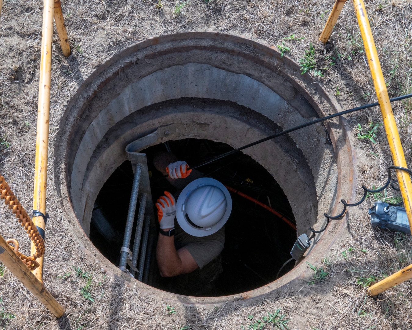 U.S. Air Force Tech. Sgt. Benjamin Dutting, a cable and antenna technician with the 212th Engineering Installation Squadron (EIS), feeds fiber optic cable through a communications conduit during an infrastructure upgrade on Otis Air National Guard Base, Massachusetts, August 8, 2025.