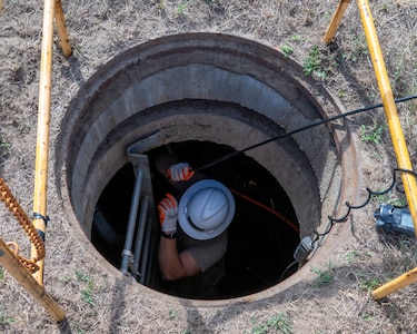 U.S. Air Force Tech. Sgt. Benjamin Dutting, a cable and antenna technician with the 212th Engineering Installation Squadron (EIS), feeds fiber optic cable through a communications conduit during an infrastructure upgrade on Otis Air National Guard Base, Massachusetts, August 8, 2025.