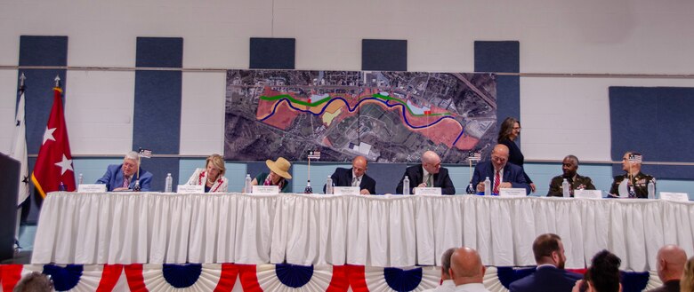 Long table with people signing documents