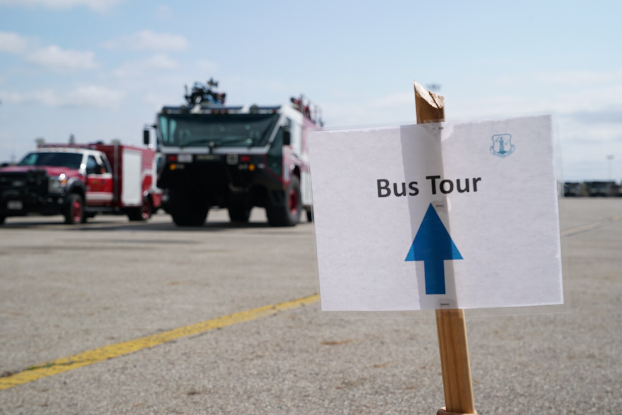 A ‘Bus Tour’ sign sits in front of two 178th Wing fire trucks, during the 2025 Springfield Air National Guard Base Community Day, on base in Springfield, Ohio, April 10, 2025. The wing invited local community leaders to participate in many briefings on the wing’s capabilities, a base tour, and an equipment display. The day concluded with a guided bus tour around the instillation, with lunch following. (U.S. Air National Guard photo by Staff. Sgt. Jillian Maynus)
