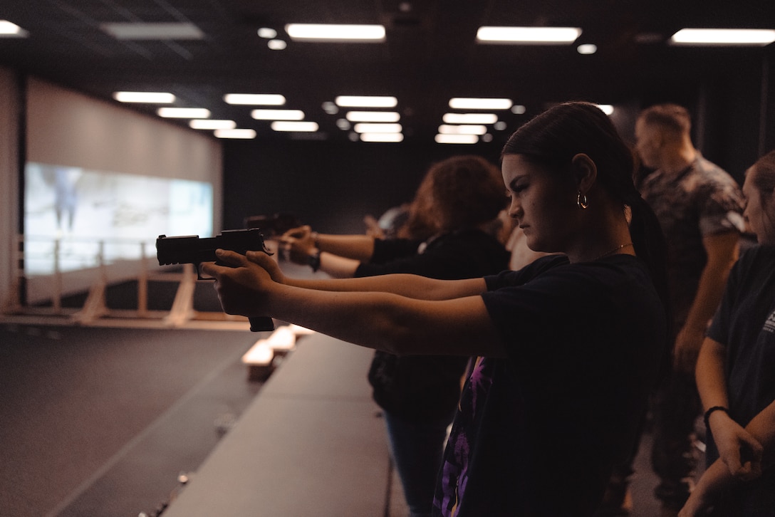 Students with the Lejeune High School Marine Corps Junior Reserve Officers’ Training Corps dryfire training M18 pistols during a visit to the Indoor Simulated Marksmanship Trainer (ISMT) on Marine Corps Base Camp Lejeune, Aug. 5, 2025. Students visited the ISMT to gain a higher understanding of Marine Corps tactics and weapons systems. (U.S. Marine Corps photo by Cpl. Loriann Dauscher)