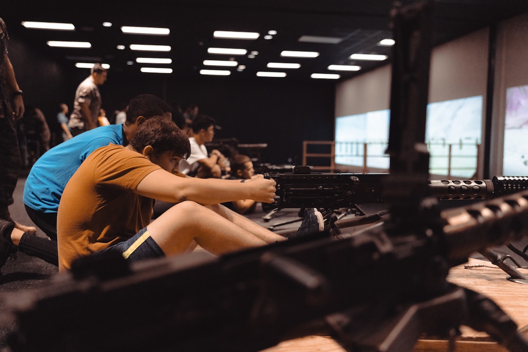 A student with the Lejeune High School Marine Corps Junior Reserve Officers’ Training Corps dryfires a training M2A1 .50 caliber machine gun during a visit to the Indoor Simulated Marksmanship Trainer (ISMT) on Marine Corps Base Camp Lejeune, Aug. 5, 2025. Students visited the ISMT to gain a higher understanding of Marine Corps tactics and weapons systems. (U.S. Marine Corps photo by Cpl. Loriann Dauscher)