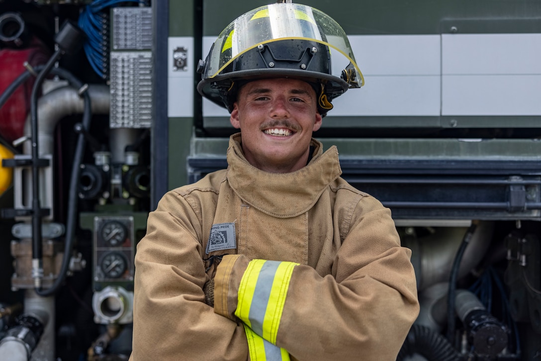U.S. Marine Corps Cpl. Aaron Smith, an expeditionary firefighting and rescue specialist with Aircraft, Rescue, and Firefighting, Marine Corps Air Station Cherry Point, stands beside a P-19R ARFF truck at MCAS Cherry Point, North Carolina, July 11, 2025.