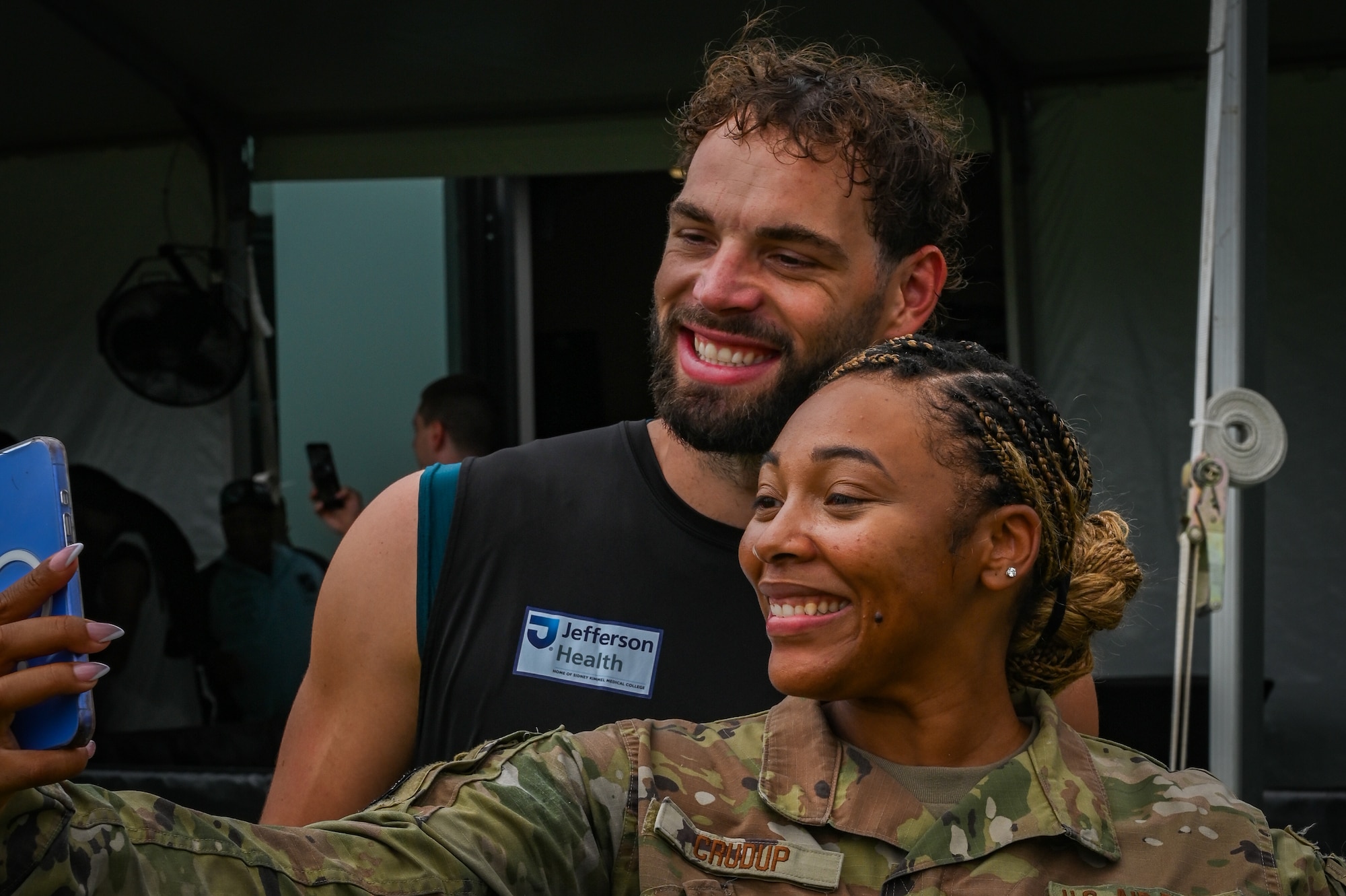 New Jersey Air National Guardsman Tech Sgt. Paula Crudup, a production recruiter with the 108th wing poses for a photo with Philadelphia Eagles tight end Dallas Goedert during Military Appreciation Day, hosted by the Philadelphia Eagles, July 26, 2025. Military Appreciation Day brought together the Eagles and local USO organizations to honor service members representing all branches from across Pennsylvania, New Jersey, and Delaware. (Pennsylvania Air National Guard photo by Staff Sgt. Charles Casner)