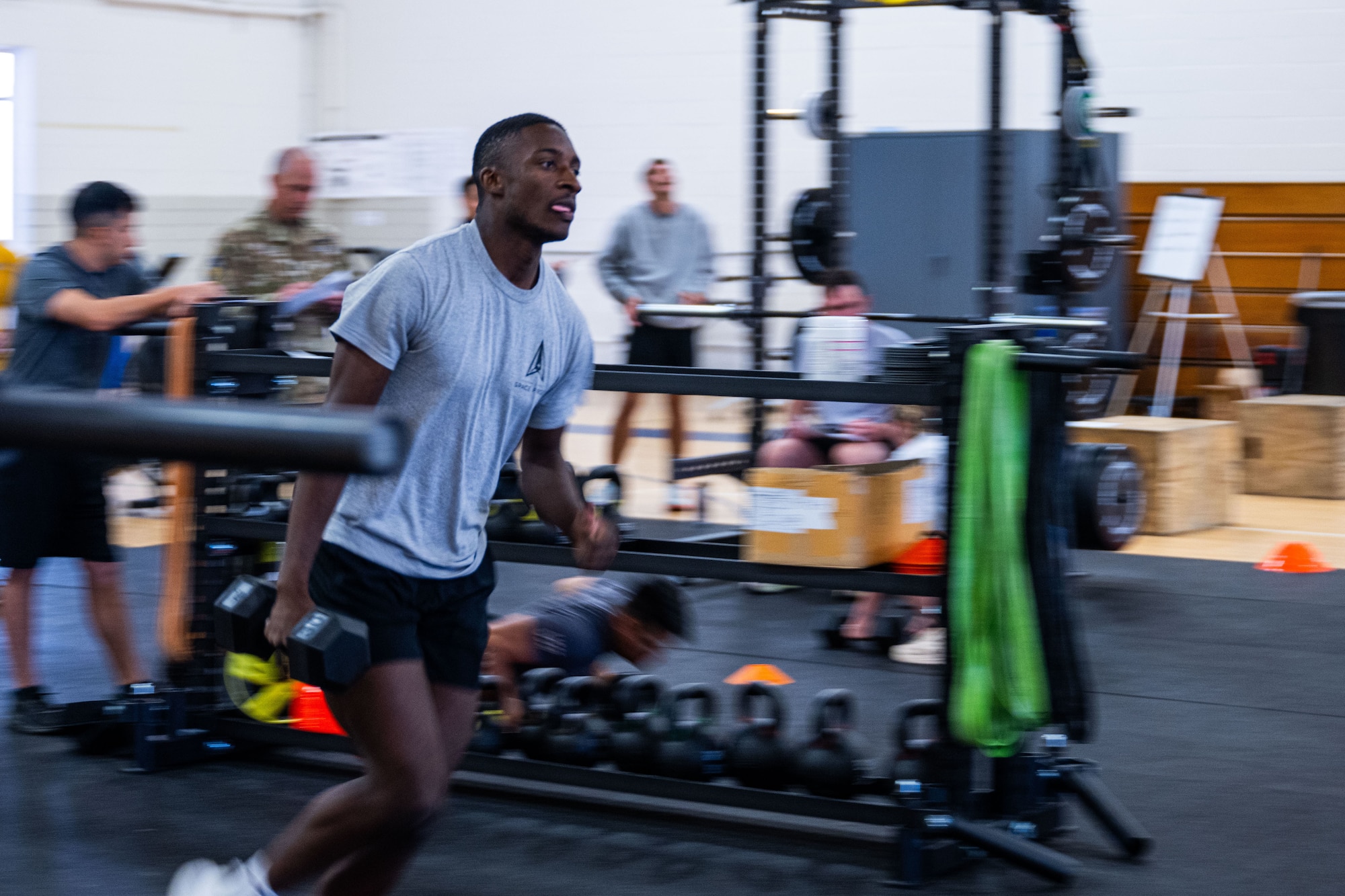 A military member in physical training gear performs a physical challenge.