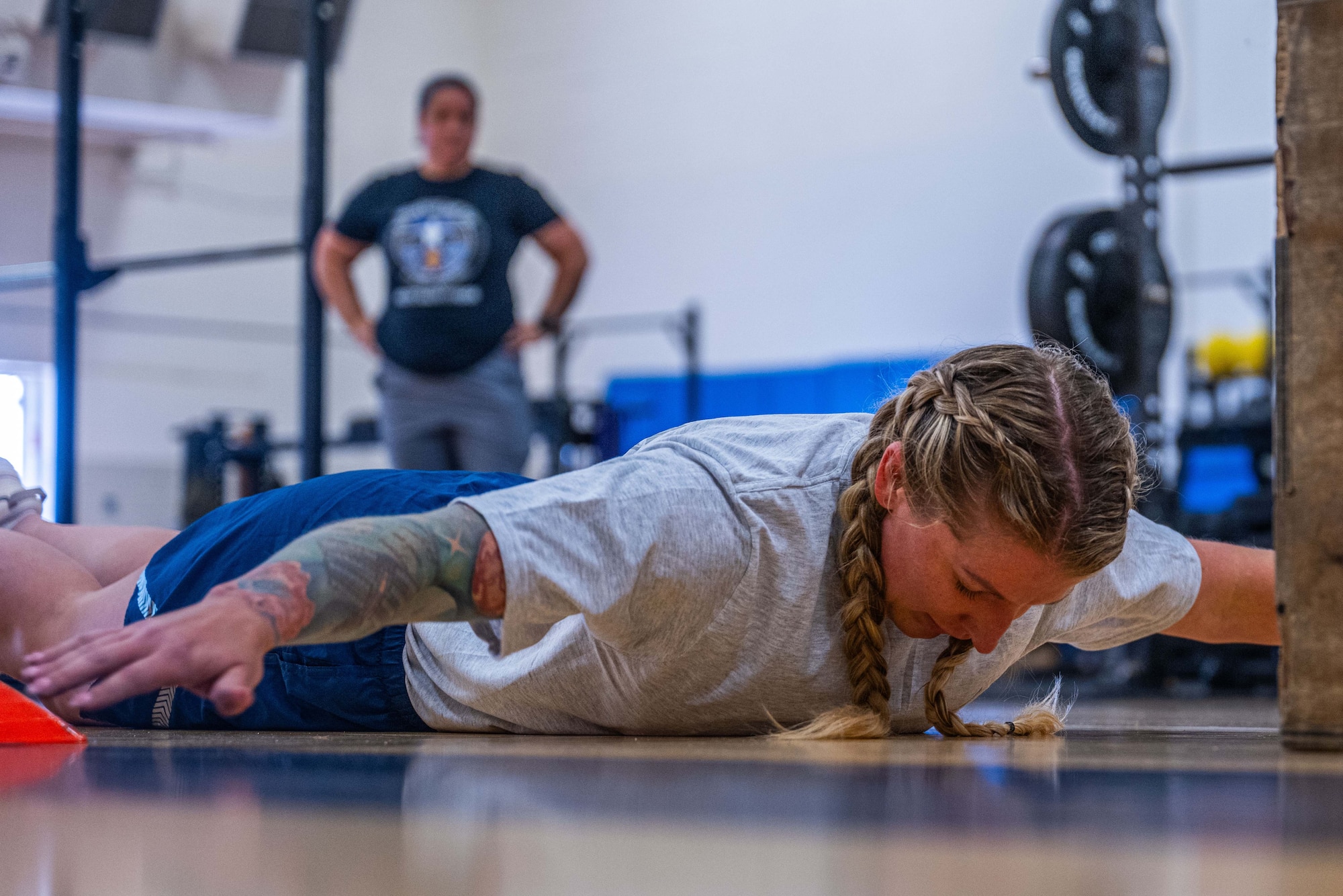 a military member in physical training gear performs a physical challenge.