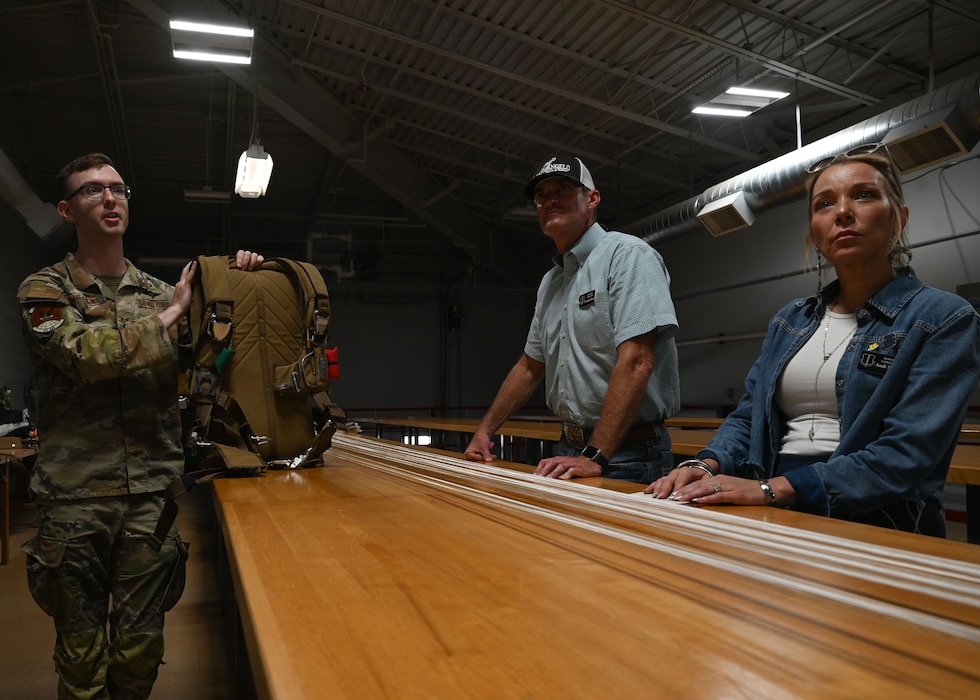 17th Training Wing honorary commanders are briefed on parachute packing by U.S. Air Force Staff Sgt. Benjamin Meadows, 317th Operational Support Squadron aircrew flight equipment craftsman at Dyess Air Force Base, Texas, Aug. 6, 2025. Dyess hosted a tour for Dyess and Goodfellow honorary commanders, providing insight into base operations and fostering partnerships between the military and local communities.