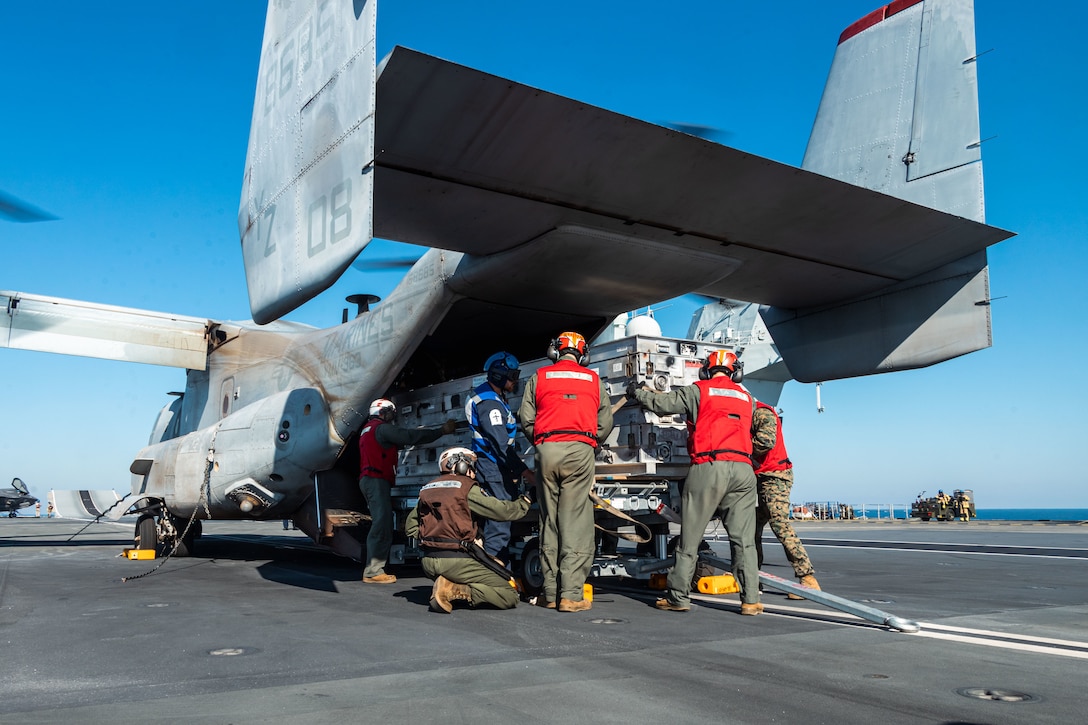 U.S. Marines with Marine Fighter Attack Squadron (VMFA) 242, Marine Aircraft Group 12, 1st Marine Aircraft Wing, as well as Marine Aviation Logistics, Marine Aircraft Group 11, 3rd Marine Aircraft Wing, and a Royal Navy Sailor offload ordnance from a MV-22B Osprey assigned to Marine Medium Tiltrotor Squadron (VMM) 363, Marine Rotational Force – Darwin 25.3, onto the HMS Prince of Wales, a Royal Navy Queen Elizabeth-class aircraft carrier, off the coast of Australia, July 21, 2025. MRF-D is an annual six-month rotational deployment to enhance interoperability with the Australian Defence Force and allies and partners and provide a forward postured crisis response force in the Indo-Pacific. (U.S. Marine Corps photo by Cpl. Anita Ramos)