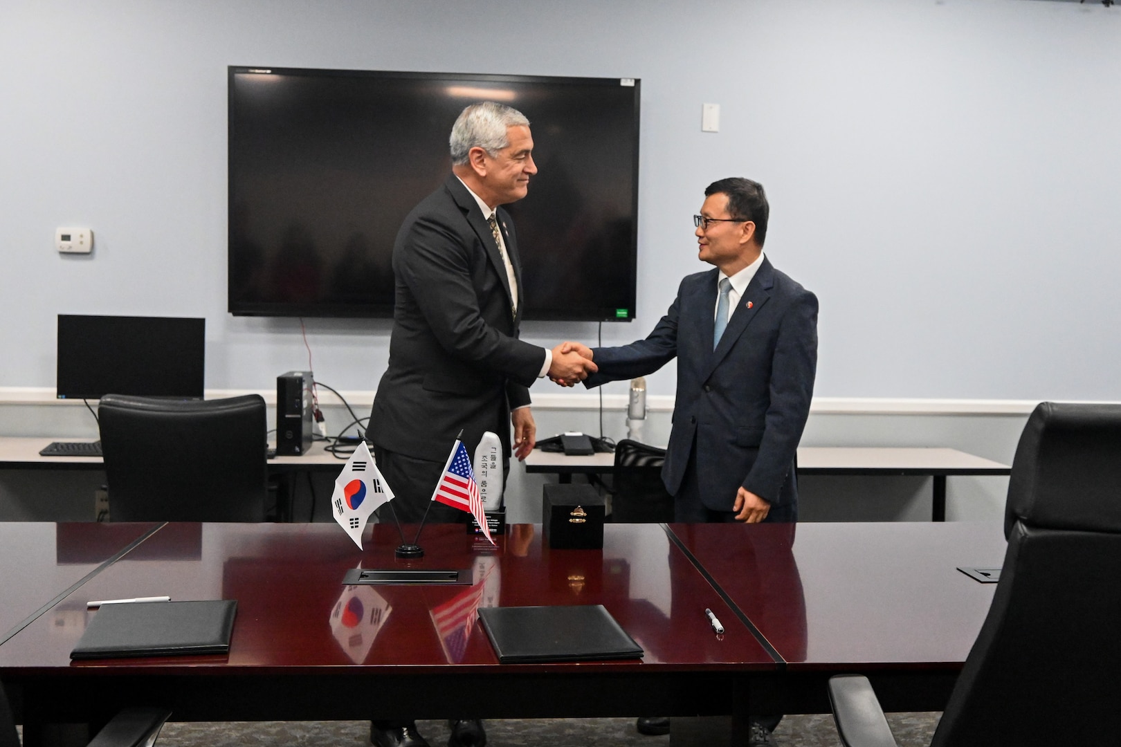 The Defense POW/MIA Accounting Agency Director, Kelly McKeague, left, and the Republic of Korea Ministry of National Defense Agency for KIA Recovery and Identification Director, Keun-Won Lee, shake hands during a Memorandum of Understanding signing ceremony in Arlington, Virginia, solidifying their commitment to recovering and identifying remains of service members missing from the Korean War, Aug. 6, 2025.