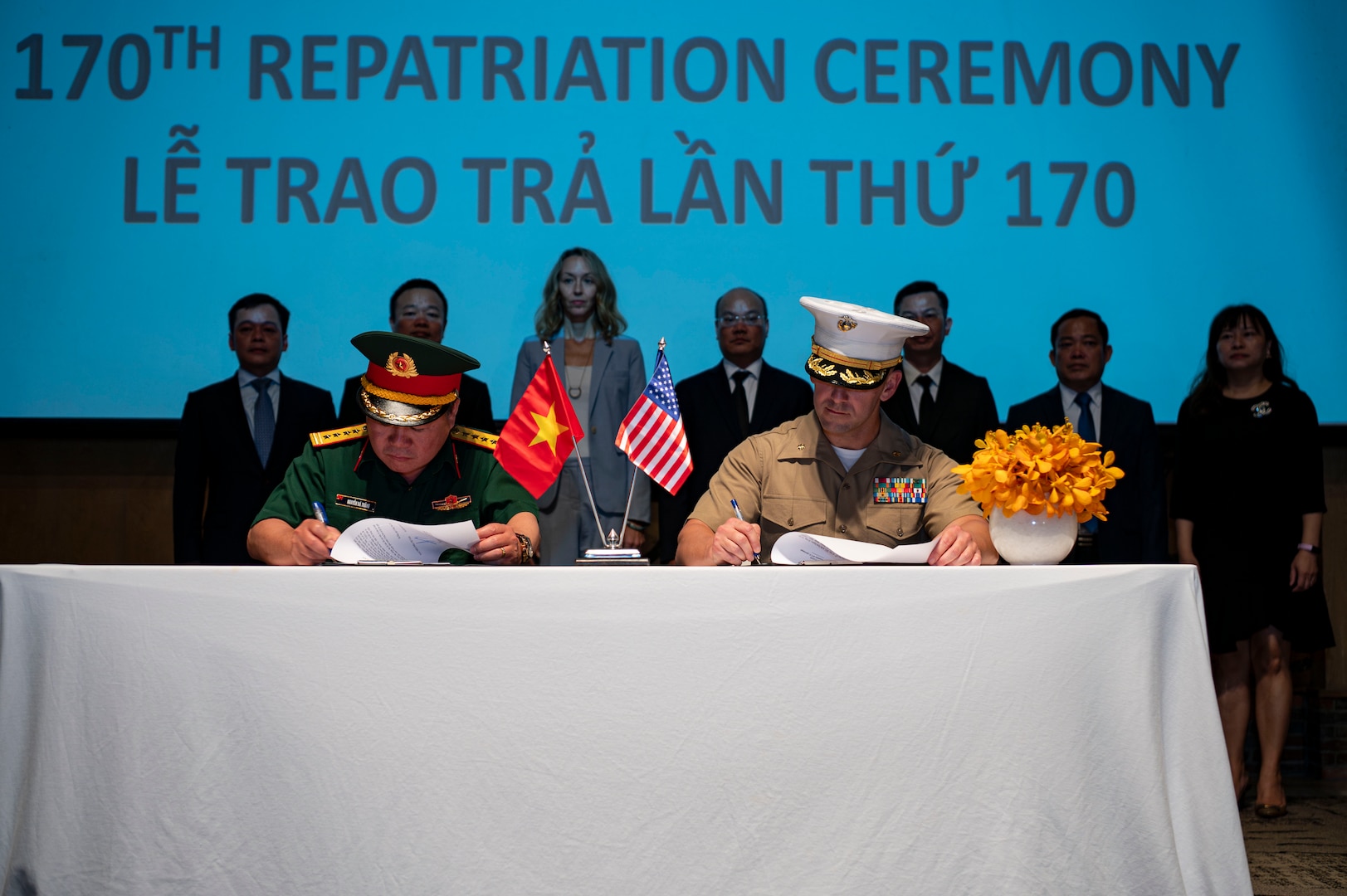 Vietnam army Gen. Nguyen Ba Thang, left, Vietnamese Office for Seeking Missing Persons, and U.S. Marine Maj. Matthew Brousseau, deputy commander of Vietnam Detachment 2, sign transfer documents at the start of a repatriation ceremony in Da Nang Province, Vietnam, July 25, 2025.