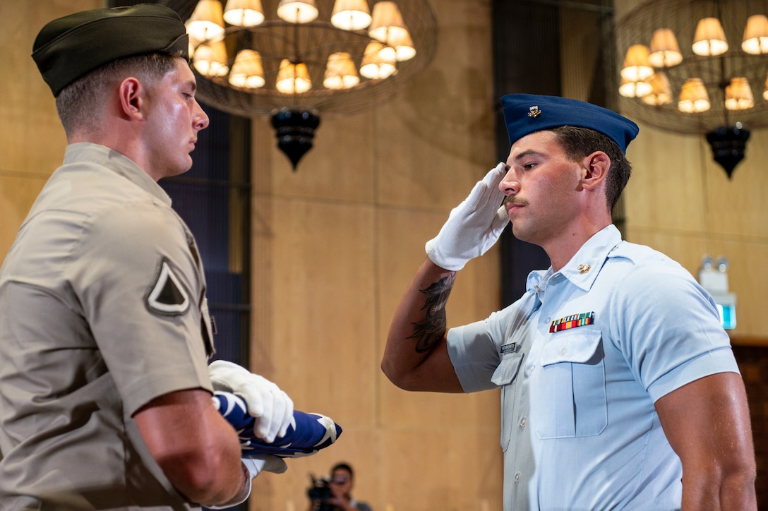 U.S. Coast Guard Petty Officer 2nd Class Gabriel Rovira Santos, right, a diver assigned to Regional Dive Locker East, salute the American flag held by U.S. Army Pfc. Shane Scott, a diver assigned to 7th Engineer Dive Detachment, during a repatriation ceremony in Da Nang Province, Vietnam, July 25, 2025.