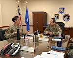 Leadership sits at table to discuss cyber partnership.