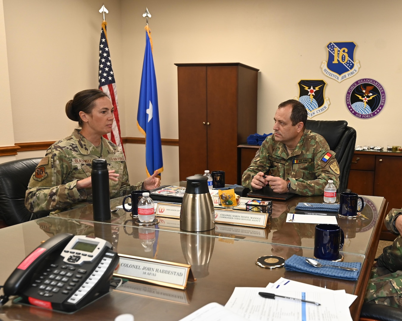 Leadership sits at table to discuss cyber partnership.