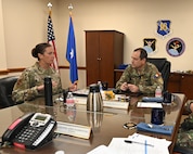 Leadership sits at table to discuss cyber partnership.