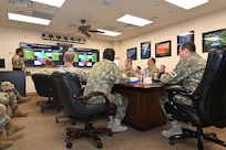 Leadership sits at table to discuss cyber partnership.