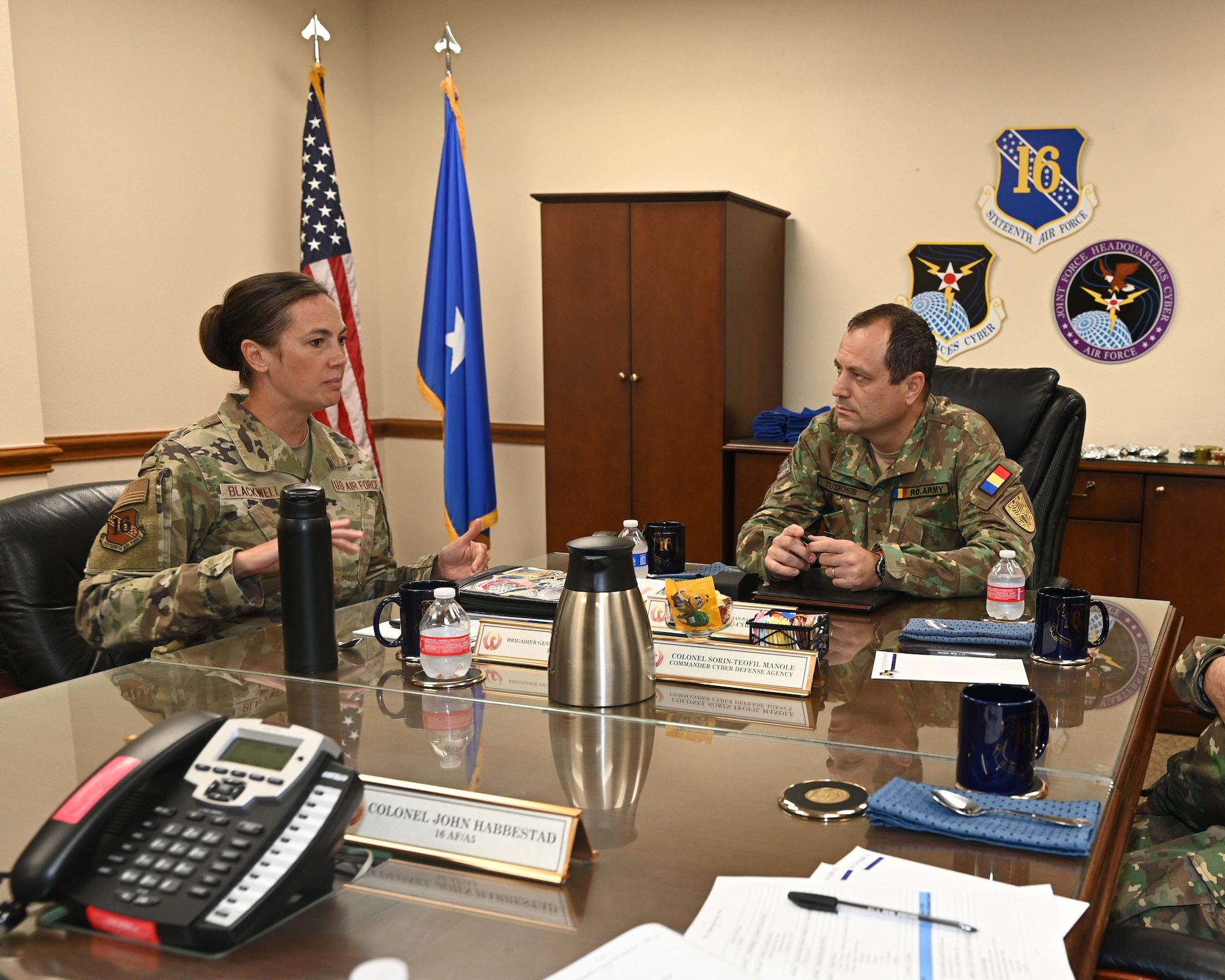 Leadership sits at table to discuss cyber partnership.