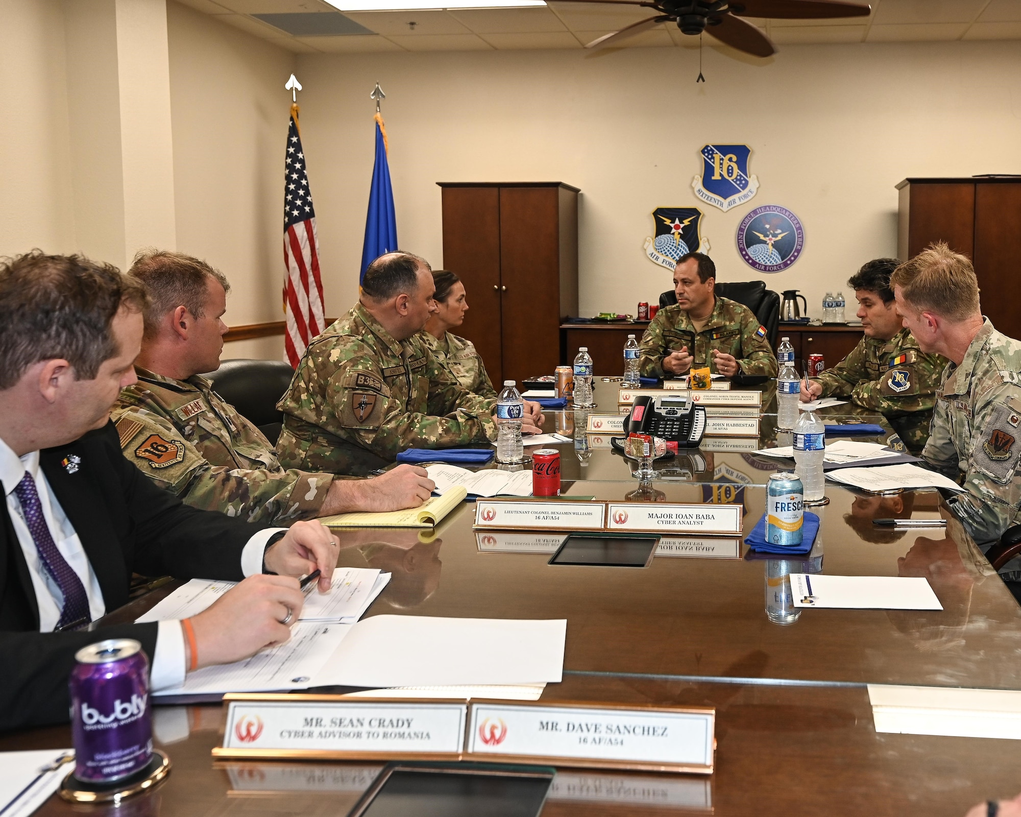 Leadership sits at table to discuss cyber partnership.
