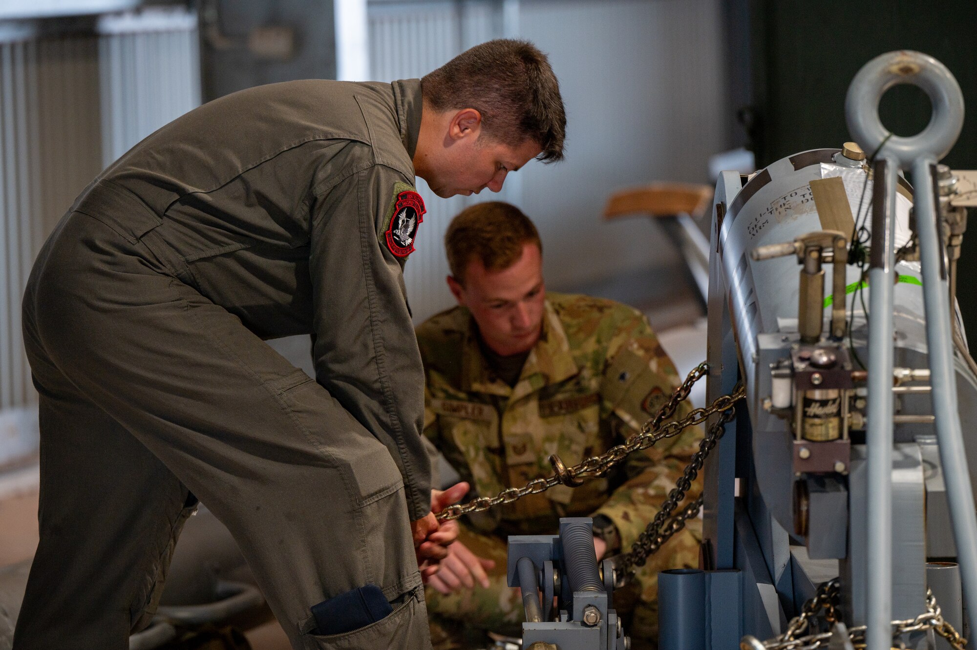 U.S. Air Force Master Sgt. Andrew Abney, left, 2nd Air Refueling Squadron boom operator and Talisman Sabre 2025 senior enlisted leader, secures cargo chains to a pallet during KC-46 operations in support of TS25 in Northern Territory, Australia, July 25, 2025. Talisman Sabre is the largest bilateral military exercise between Australia and the United States, that advances a safe and secure Indo-Pacific by strengthening relationships and interoperability among key Allies and partners, while enhancing collective capabilities to respond to a wide array of potential security concerns. (U.S. Air Force photo by Senior Airman Clare Werner)