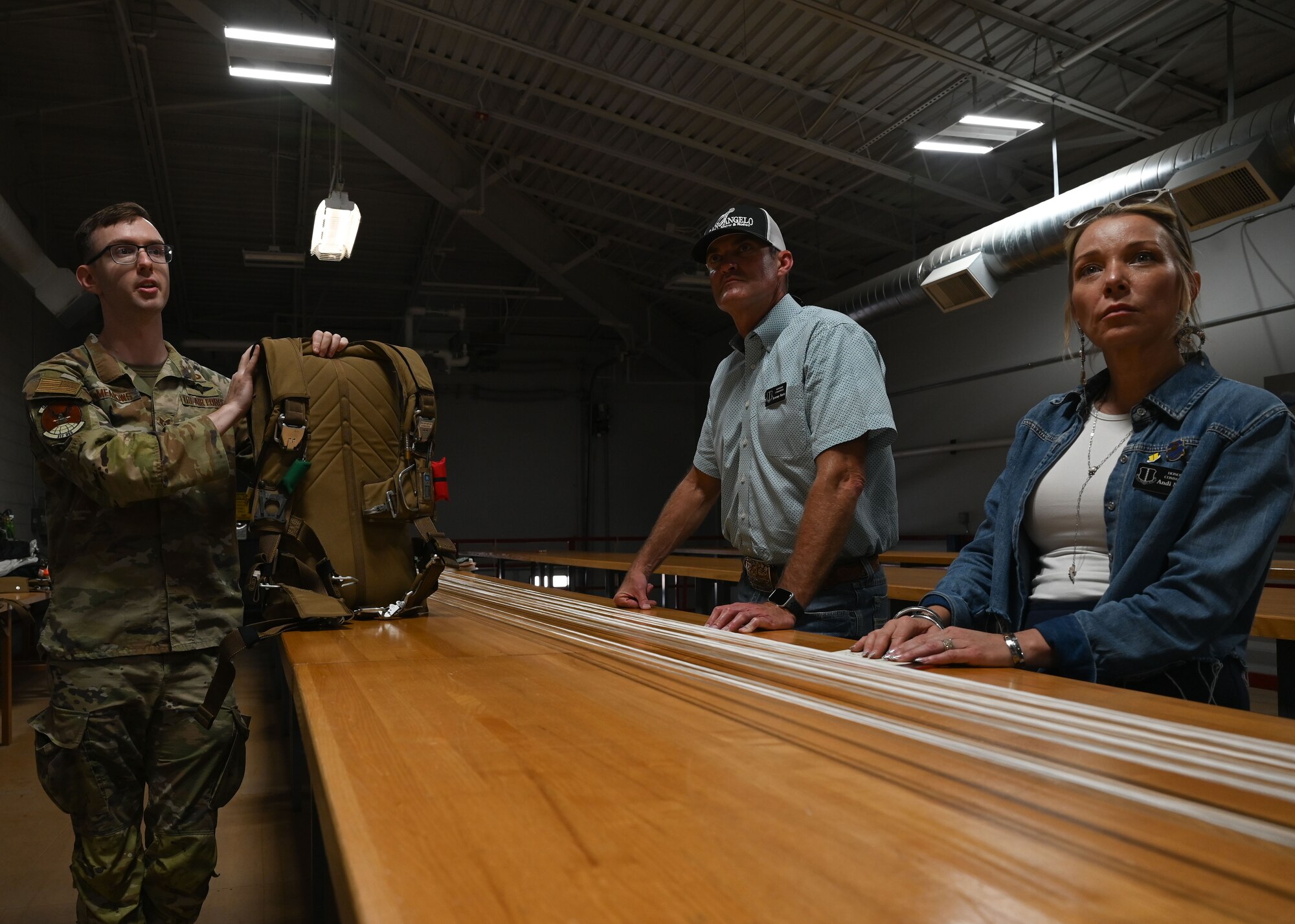 17th Training Wing honorary commanders are briefed on parachute packing by U.S. Air Force Staff Sgt. Benjamin Meadows, 317th Operational Support Squadron aircrew flight equipment craftsman at Dyess Air Force Base, Texas, Aug. 6, 2025. Dyess hosted a tour for Dyess and Goodfellow honorary commanders, providing insight into base operations and fostering partnerships between the military and local communities.