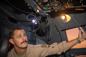 A U.S. Air Force flight engineer, assigned to the 41st Expeditionary Electronic Combat Squadron performs preflight checks of EC-130H Compass Call within the U.S. Central Command area of responsibility, July 22, 2025. The 41st EECS has the unique mission of interfering with enemy communications making their coordination less effective. (U.S. Air Force photo by Staff Sgt. Sean Moriarty)
