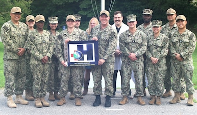 Navy Medicine Readiness and Training Command (NMRTC) Patuxent River leadership and staff celebrate the Silver Eagle "Blue H" award for 2024. Four local Naval Medical Commands have earned prestigious recognition for their outstanding contributions to health promotion and wellness. NMRTC Patuxent River oversees Naval Medical Readiness Training Unit (NMRTU) Dahlgren, NMRTC Detachment Indian Head, and NMRTC Detachment Joint Base Andrews (JBA).  All four commands have been recognized by the Navy Surgeon General, as receiving the Navy Surgeon General's Health Promotion and Wellness Award for 2024.