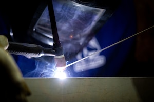 U.S. Air Force Senior Airman Matt Bercham, 379th Expeditionary Civil Engineer Squadron structural journeyman, welds a frame for a sun shade within the U.S. Central Command area of responsibility, July 16, 2025. The ECES designed sunshades in-house and created them from leftover tent parts. (U.S. Air Force photo by Staff Sgt. Sean Moriarty)
