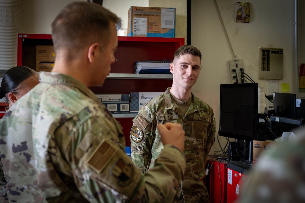 U.S. Air Force Airman stands while listening to a Airman talk.