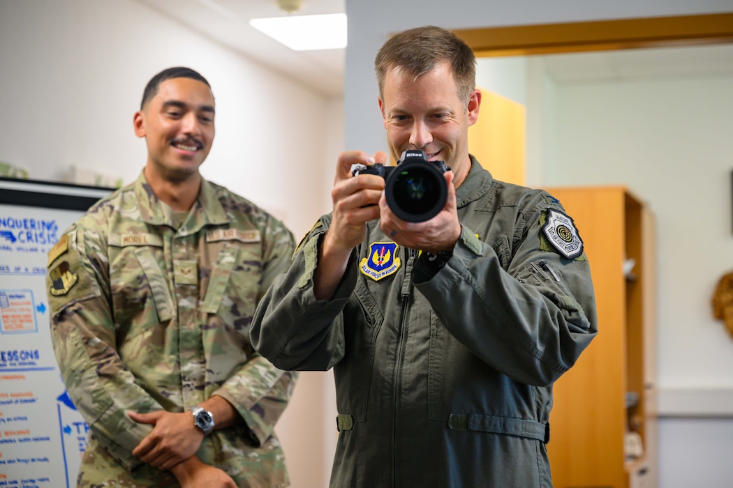 U.S. Air Force Airman holds a camera.