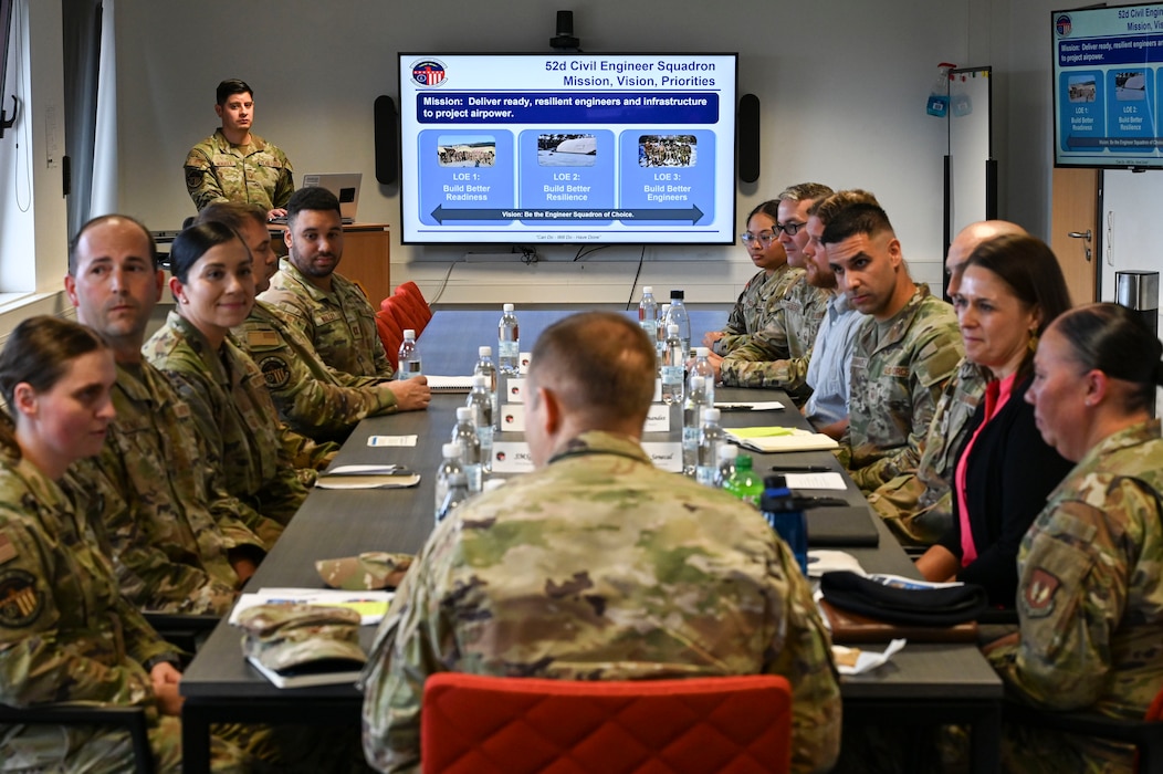 U.S. Air Force Airman sit around a table.