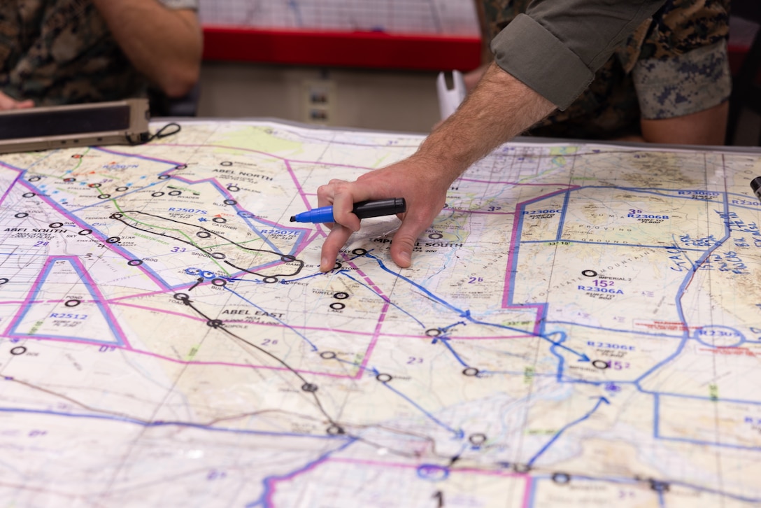 U.S. Marine Corps Capt. Wyatt Mathews, from Wyoming, a CH-53E Super Stallion pilot with Marine Heavy Helicopter Squadron (HMH) 461, Marine Aircraft Group 29, 2nd Marine Aircraft Wing (MAW), studies a map during simulated mission planning as part of Assault Support Planning Problem (ASPP) 1-26 at Marine Corps Air Station New River, North Carolina, Aug. 7, 2025. ASPP provides pilots with the opportunity to plan, brief and lead a company air assault mission prior to attending the Marine Corps’ Weapons and Tactics Instructor course. (U.S. Marine Corps photo by Cpl. Anakin Smith)