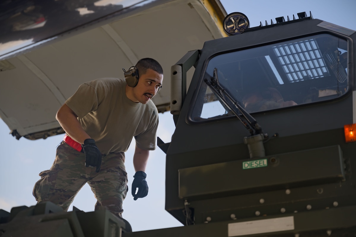 An Airman walks in front of a loading truck