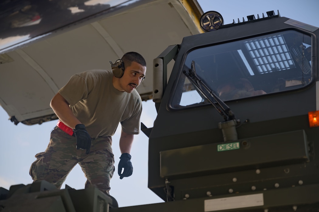 An Airman walks in front of a loading truck