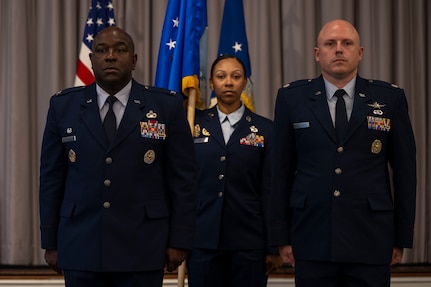 U.S. Air Force Lt. Col. Chad Polumbo, right, 2nd Intelligence Squadron incoming commander, stands alongside Col. Ryan L. O’Neal, left, 77th Intelligence Wing commander, as Senior Master Sgt. Alicia Smith, 2nd IS senior enlisted leader, carries the Air Force Provisional Flag in lieu of a guidon for Polumbo’s assumption of command ceremony at Joint Base Anacostia-Bolling, Washington, D.C., July 29, 2025.