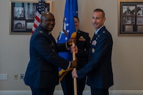 U.S. Air Force Col. Ryan L. O’Neal, left, 77th Intelligence Wing commander, transfers command of the 15th Intelligence Squadron to Lt. Col. Amy Natalani, right, while Senior Master Sgt. Carley Blackwell, center, 15th IS senior enlisted leader, stands at attention during a dual assumption of command ceremony at Joint Base Anacostia-Bolling, Aug. 8, 2025.