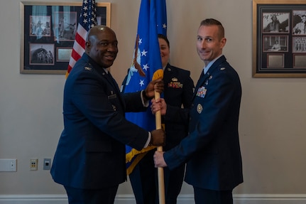 U.S. Air Force Col. Ryan L. O’Neal, left, 77th Intelligence Wing commander, transfers command of the 15th Intelligence Squadron to Lt. Col. Amy Natalani, right, while Senior Master Sgt. Carley Blackwell, center, 15th IS senior enlisted leader, stands at attention during a dual assumption of command ceremony at Joint Base Anacostia-Bolling, Aug. 8, 2025.