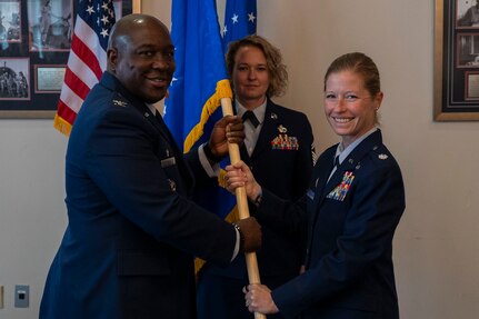 U.S. Air Force Col. Ryan L. O’Neal, left, 77th Intelligence Wing commander, transfers command of the 6th Intelligence Support Squadron to Lt. Col. Joseph Mellone, right, while Tech. Sgt. Kelsey Orvin, center, 6th ISS first sergeant, stands at attention during a dual assumption of command ceremony at Joint Base Anacostia-Bolling, Aug. 8, 2025.