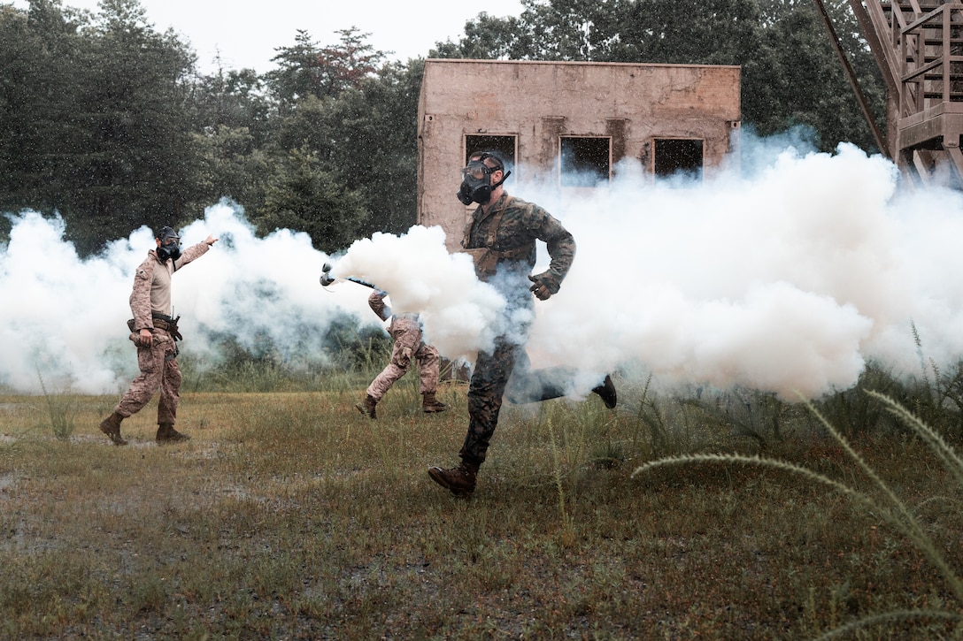 U.S. Marine Corps Warrant Officer Ryan Young, a chemical, biological, radiological, and nuclear (CBRN) defense officer with 2nd Battalion, 2nd Marine Regiment, spreads chlorobenzylidene malononitrile (tear gas) around a simulated urban area during urban operations training at Marine Corps Base Quantico, Virginia, July 31, 2025.