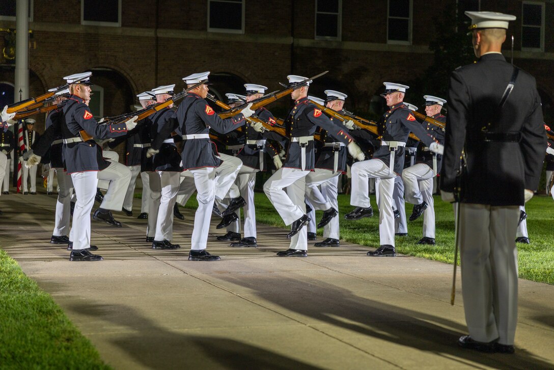 U.S. Marines with the United States Marine Corps Silent Drill Platoon perform a manuever during the Friday Evening Parade at Marine Barracks Washington, D.C., Aug. 8, 2025. The Evening Parade is a symbol of tradition and heritage of the Marine Corps. This parade was hosted Lt. Gen. Leonard Anderson IV, commander, United States Marine Corps Forces Reserves and Marine Corps Forces South, in honor of Mr. Greg Norman, Chief Executive Officer, Chairman and founder of the Greg Norman Company. (U.S. Marine Corps photo by Sgt. Samuel Qin)