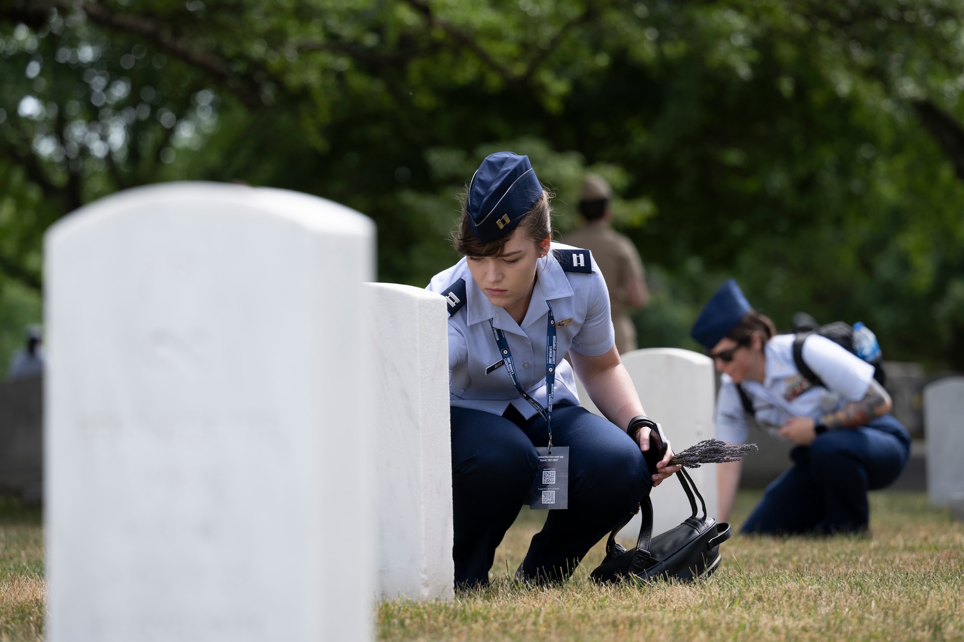 Members of the Sea Services Leadership Association (SSLA) lay lavender at gravesites in Section 11 of Arlington National Cemetery, Arlington, Virginia, June 28, 2024.
