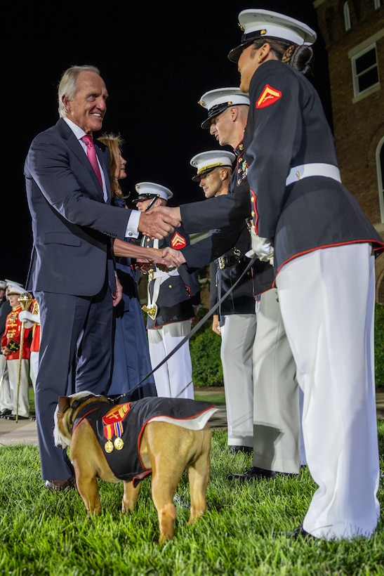 Mr. Greg Norman, Chief Executive Officer, Chairman and founder of the Greg Norman Company, thanks a U.S. Marine Corps mascot handler of Cpl. Chesty XVI, the official mascot of Marine Barracks Washington,  after a performance at the Friday Evening Parade at Marine Barracks Washington, D.C., Aug. 8, 2025. The Friday Evening Parade is a symbol of tradition and heritage of the Marine Corps. This parade, hosted by U.S. Marine Corps Lt. Gen. Leonard F. Anderson IV, commander of Marine Forces Reserve and Marine Forces South, was held in honor of Norman. (U.S. Marine Corps photo by Sgt. Samuel Qin)