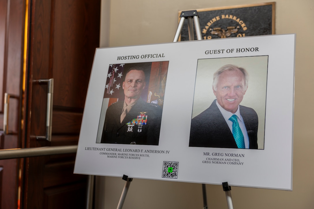 A sign displaying the hosting official and the guest of honor for the Friday Evening Parade at Marine Barracks Washington, D.C., Aug. 8, 2025. The Friday Evening Parade is a symbol of tradition and heritage of the Marine Corps. (U.S. Marine Corps photo by Sgt. Samuel Qin)