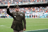 Sgt. 1st Class Charles Almburg waves to thousands of cheering football fans during the Chicago Bears’ Military Salute at Soldier Field in Chicago, August 10, 2025.
