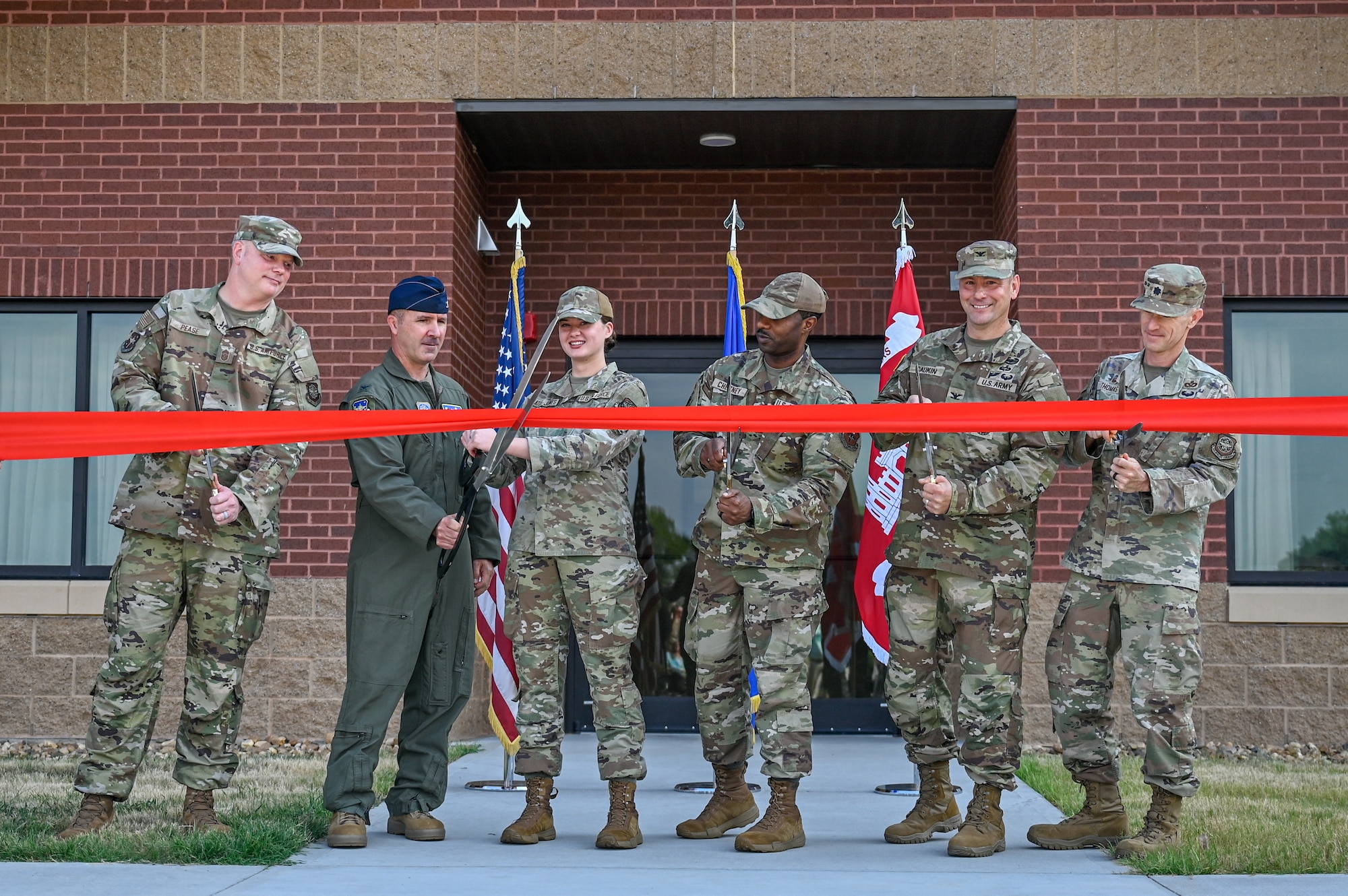 Members of Team Little Rock and the U.S. Army Corps of Engineers cut a ribbon to dedicate new dorms at Little Rock Air Force Base, Arkansas, Aug. 12, 2025. The dorms add 136 resident rooms, bringing the dorm campus capacity to a total of 586.