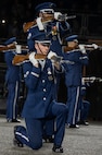 U.S. Air Force Senior Airman Crìsdean James Langan, kneeling center, ceremonial guardsman with the U.S. Air Force Honor Guard Drill Team, conducts a kneeling-bone-crusher drill movement during a performance of the 75th Royal Edinburgh Military Tattoo in Edinburgh, Scotland, Aug. 1, 2025. Military bands and drill teams from the U.S., United Kingdom, Switzerland, Canada, Germany, Poland, and Ukraine performed during the 24-day event. (U.S. Air Force photo by Hayden Hallman)